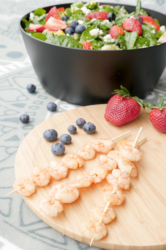 Fast prawn skewers with a fruity salad with blueberries and strawberries
